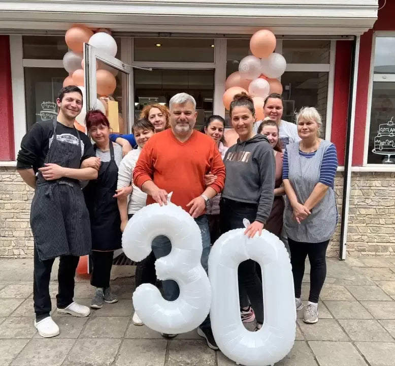 Персоналът на сладкарница Маргарита празнува своята 30-годишнина с големи балони с числа пред сладкарницата
