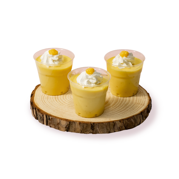 Три крем брюле в чашки, поднесени на дървена поставка от сладкарница Маргарита.