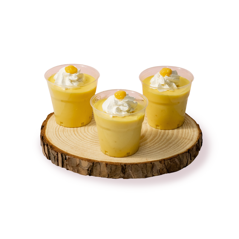 Три крем брюле в чашки, поднесени на дървена поставка от сладкарница Маргарита.